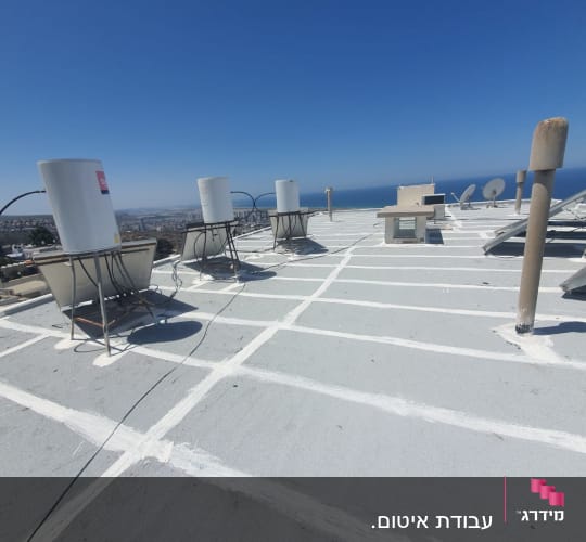 איטום גג עם חומר לבן בין לוחות בטון